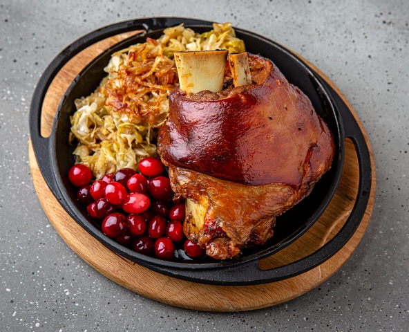 Pork knuckle in beer with stewed cabbage and cranberries